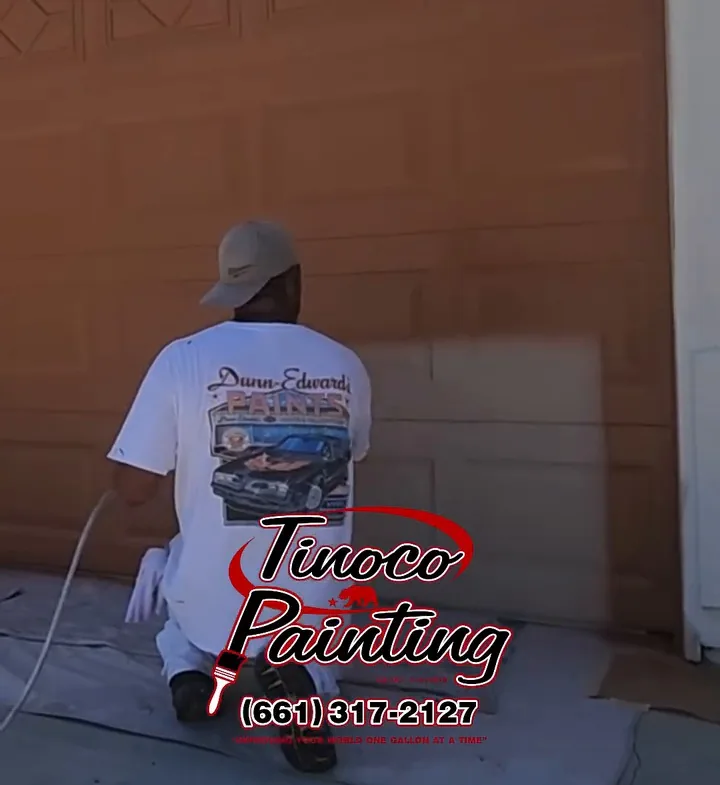 A Tinoco Painting crew member painting the bottom of a residential garage door